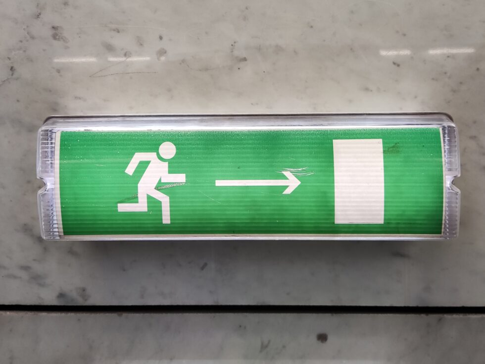 A,Beautiful,Green,Sign,With,A,Bright,Emergency,Exit,Light
